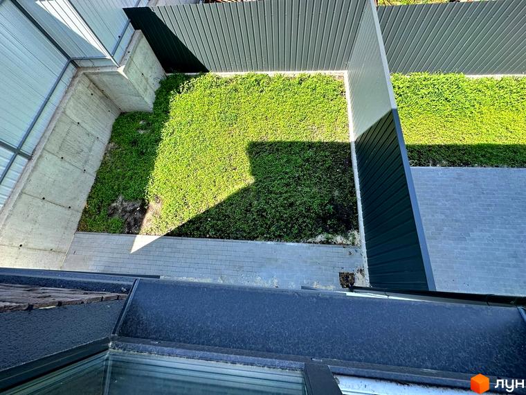 Вид зверху на таунхауси T-35 з зеленим подвір'ям. Житловий комплекс з сірими стінами та зеленим газоном.