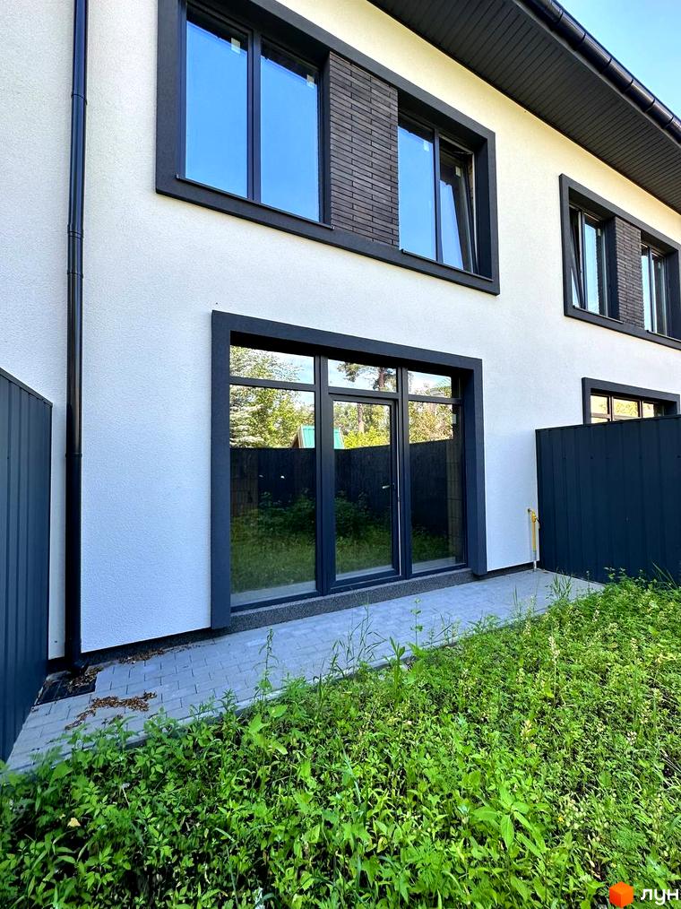 Зовнішній вигляд будинку на Ярославській, 26в. Двоповерхова будівля з великими вікнами та доглянутою прибудинковою територією.