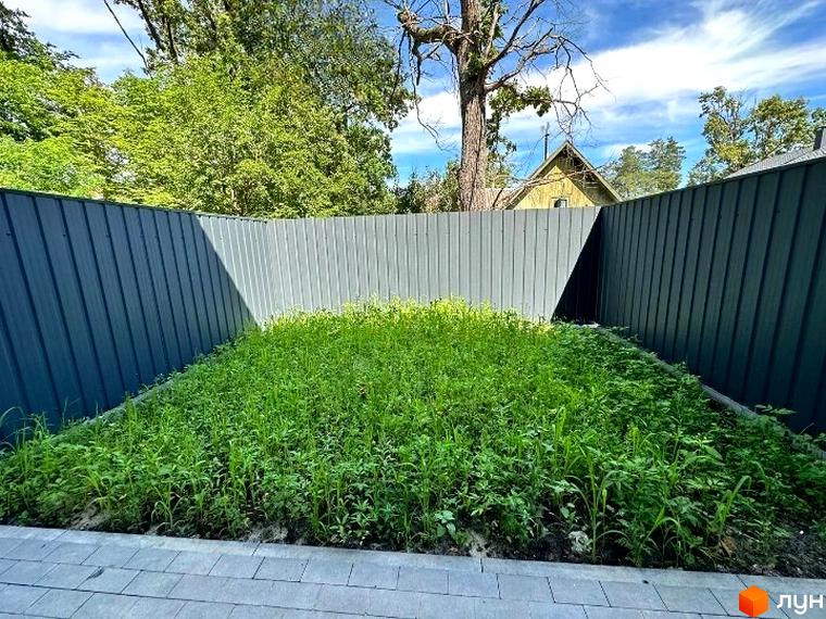 Таунхаус Т-37 з зеленим газоном та парканом. Зелена територія навколо будинку.