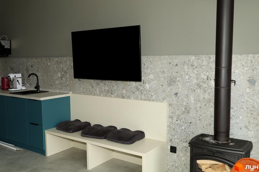 Інтер'єр кухні-вітальні з телевізором на стіні, каміном та зручним диваном. AMA FAMILY RESORT - ваш новий дім.