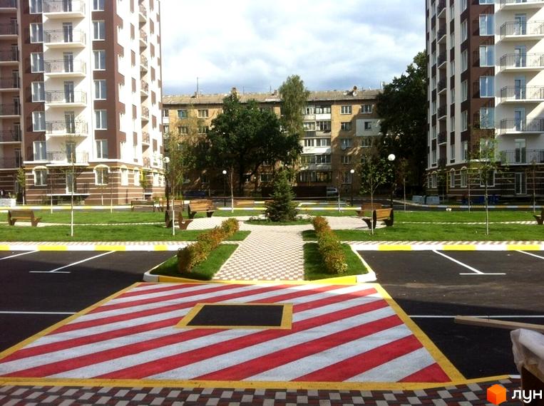 Новобудова ЖК Центральний з акуратною прибудинковою територією, парковкою та зеленими зонами. Сучасний житловий комплекс з комфортною інфраструктурою.