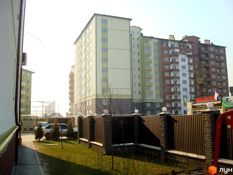 Житловий комплекс Смарагдове місто у Нових Петрівцях. Зовнішній вигляд будівель та прибудинкова територія з парканом та деревами.