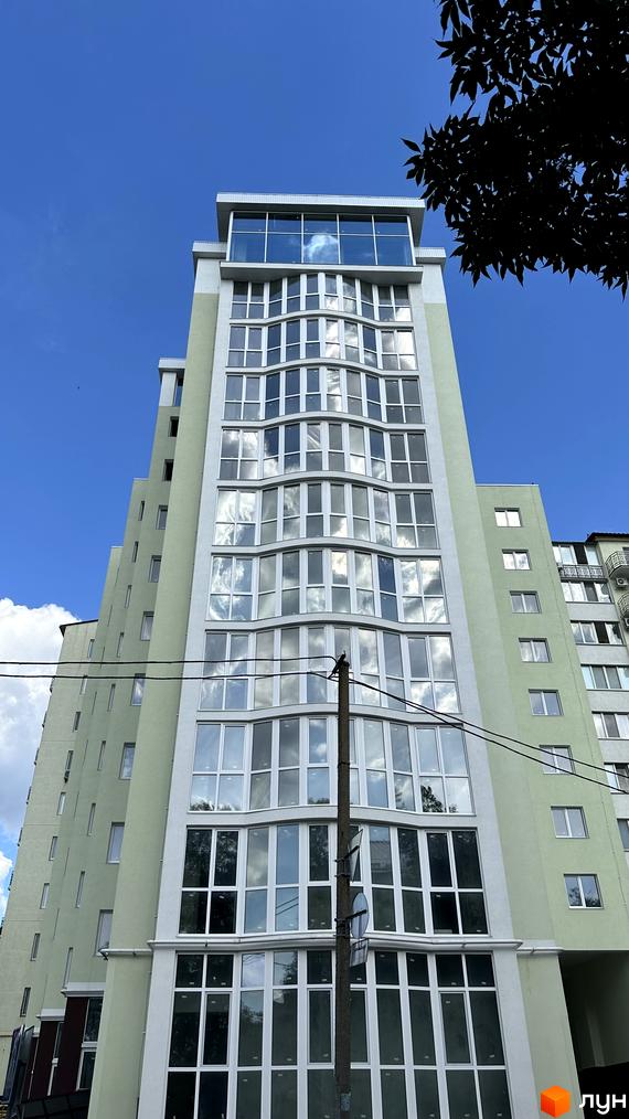 Житловий комплекс Потьомкінський: висотна новобудова зі світло-зеленим фасадом та панорамними вигнутими вікнами. Верхня частина має скляну конструкцію.