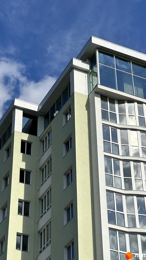 Житловий комплекс Потьомкінський має світло-зелений та білий фасади з великими вікнами та скляним верхнім поверхом.
