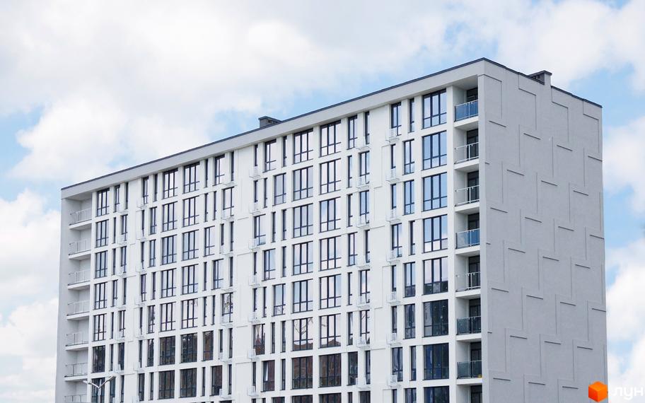 Зовнішній вигляд новобудови ЖК Kniahynyn-Center з численними вікнами та балконами. Фасад будівлі виконаний у світлих тонах.