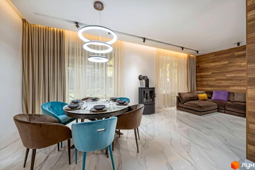 Вітальня з обідньою зоною та каміном у житловому комплексі КМ Парк хаус. Великі вікна з шторами та сучасне освітлення.