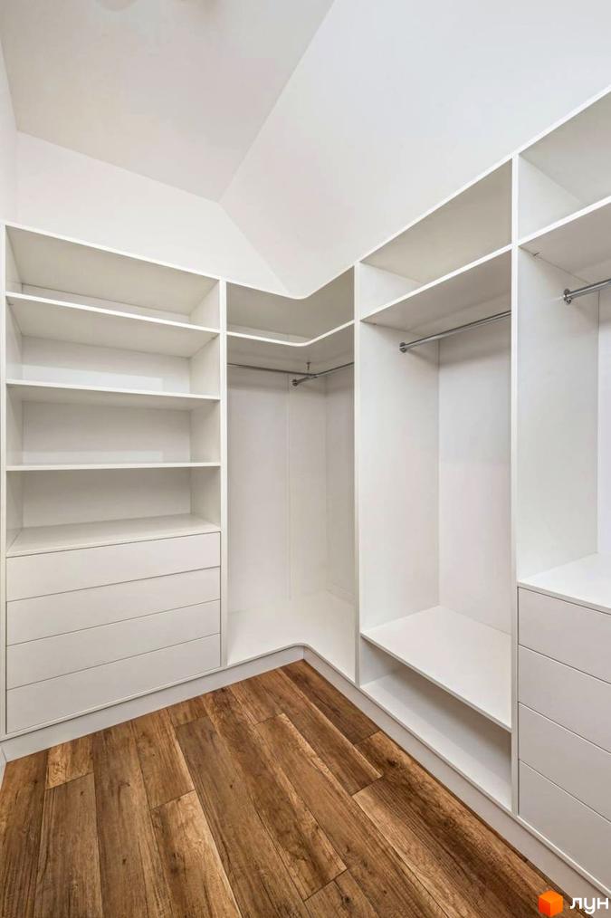 Сучасний гардероб з білими полицями та шухлядами, дерев'яна підлога. КМ Парк хаус - новобудова для вашого комфорту.