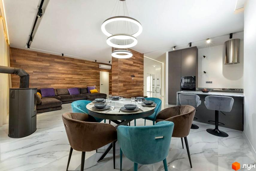 Інтер'єр вітальні з обідньою зоною житлового комплексу КМ Парк хаус. Простора кімната з диваном, круглим столом та стільцями.