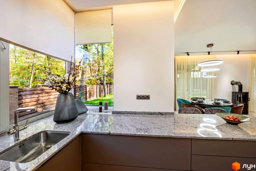 Сучасна кухня з сірим мармуровим покриттям та великим вікном, що виходить на зелений двір. Комплекс КМ Парк хаус.