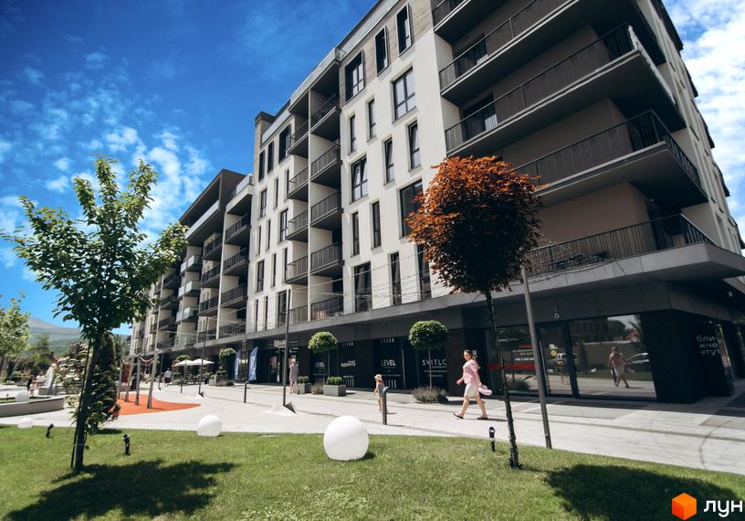 Новобудова ЖК Sky Towers з балконами та прибудинковою територією з деревами та газоном.