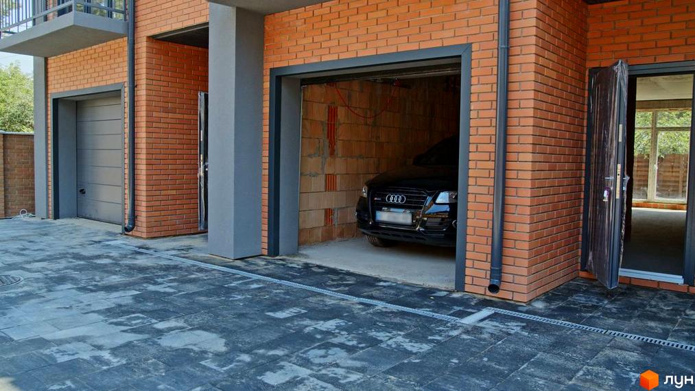 Таунхауси „Позітано Центр“: фасади з цегли, гаражні ворота, вхідні двері та вимощена прибудинкова територія. Зовнішній вигляд комплексу.
