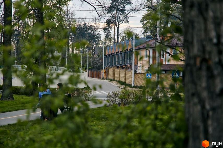 Вигляд на Котеджне містечко Positano Park з вулиці. Видно фасади будинків та пішохідний перехід.