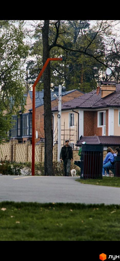 Зображення Котеджного містечка Positano Park: цегляні будинки з черепичними дахами, зелена територія з деревами та пішохідними доріжками.