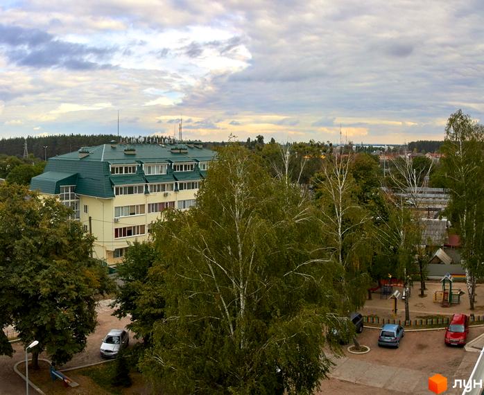 Житловий комплекс Милі квартири: багатоповерховий будинок із зеленим дахом та прибудинковою територією з дитячим майданчиком та парковкою.