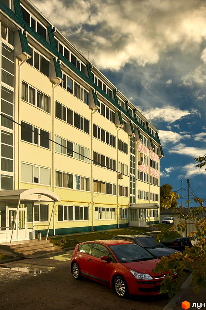 Житловий комплекс Милі квартири – це багатоповерхова будівля світло-жовтого кольору із зеленим дахом. Перед будинком розташований паркінг та зелені насадження.