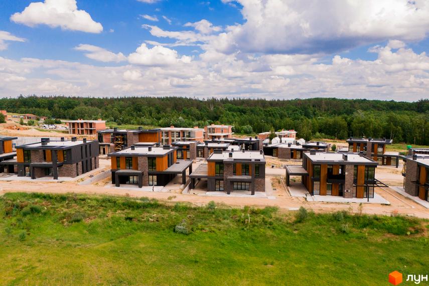 Котеджне містечко КМ 9 ЕЛЕМЕНТІВ – це сучасна забудова з двоповерхових будинків з панорамними вікнами та оздобленням фасаду каменем та деревом. Навколо будинків облаштована прибудинкова територія з зеленими насадженнями.