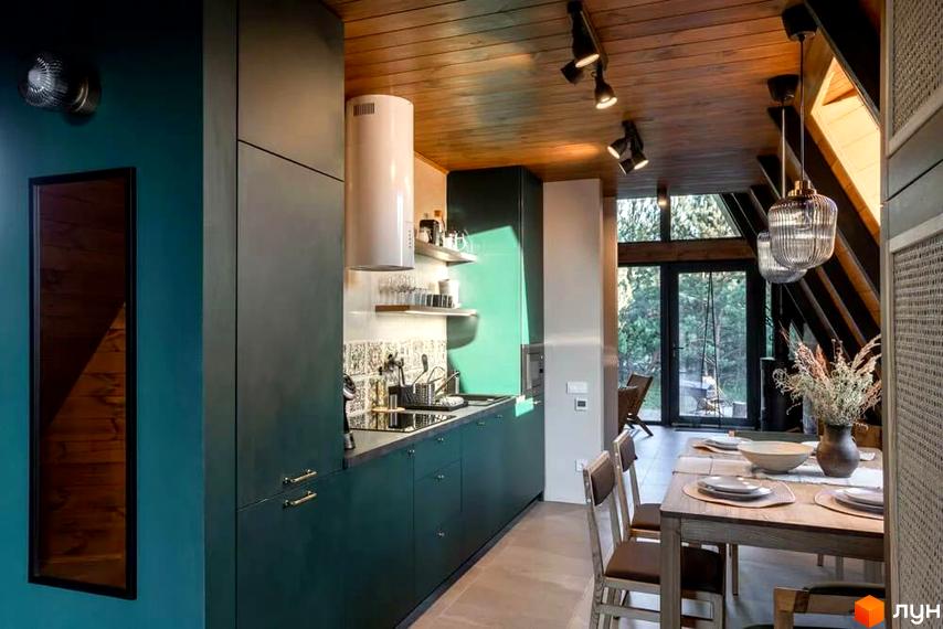 Інтер'єр кухні-вітальні в комплексі відпочинку УЛІС з дерев'яною стелею та великими вікнами, що виходять на ліс.