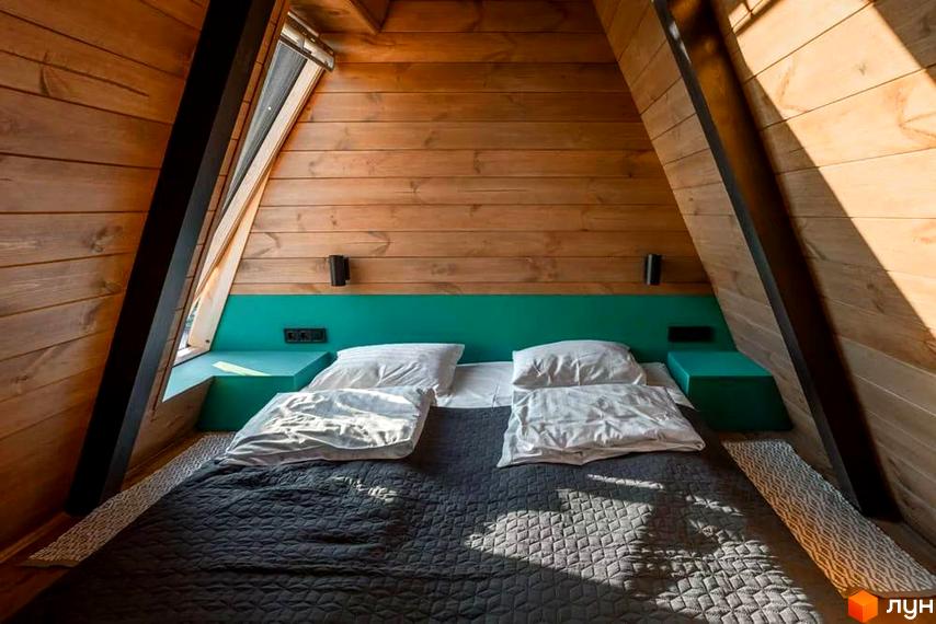 Затишна спальня в дерев'яному будиночку комплексу відпочинку УЛІС. А-подібна конструкція стін та стелі створює унікальний інтер'єр.