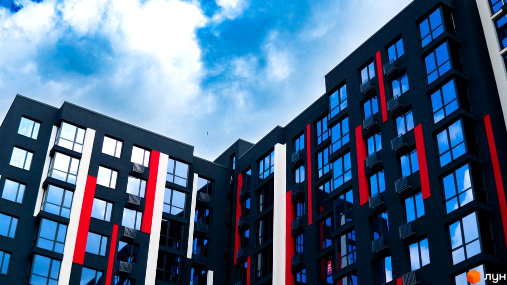 Житловий комплекс Union - це сучасна новобудова з яскравими червоно-білими смугами на фасаді та великими вікнами, що відбивають небо.