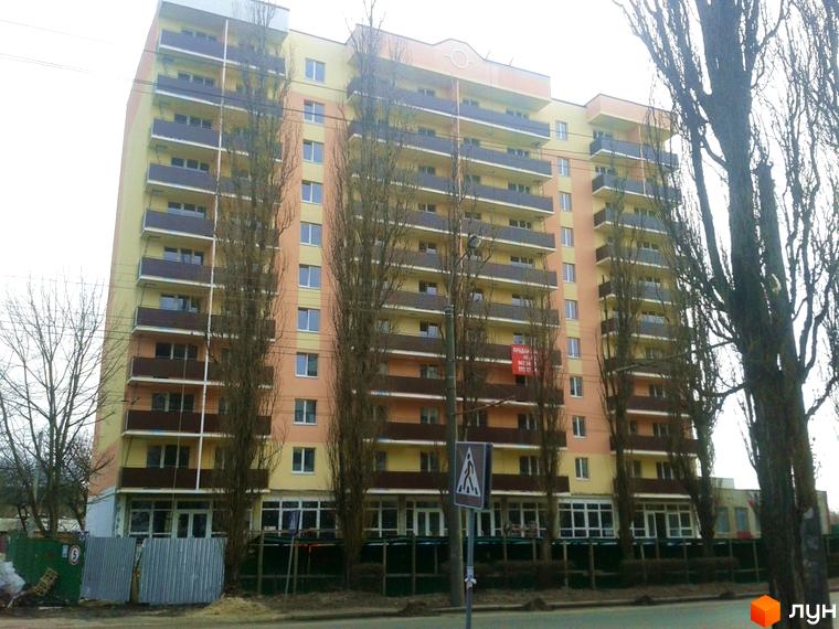 Новобудова ЖК Соборний: висотна багатоповерхівка з балконами та вікнами. Перед будинком дерева та пішохідний перехід.