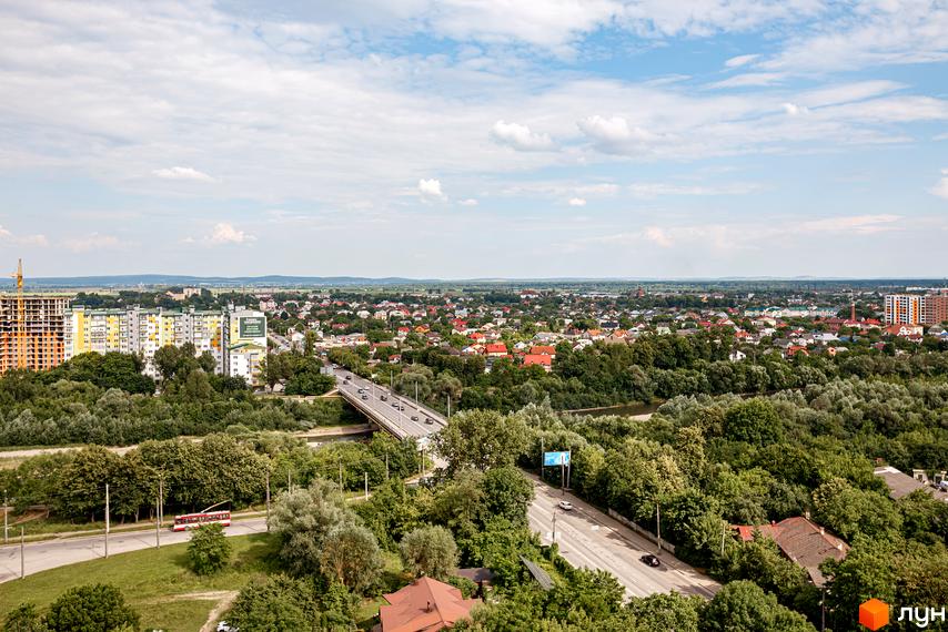 Вид на житловий комплекс Lystopad з висоти пташиного польоту. Комплекс розташований серед зелені, з видом на міський пейзаж та міст.