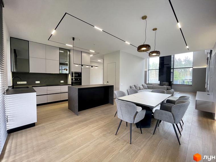 Інтер'єр кухні-вітальні в Котеджному містечку Нова Ходосівка. Просторе приміщення з великим обіднім столом та кухонним гарнітуром.