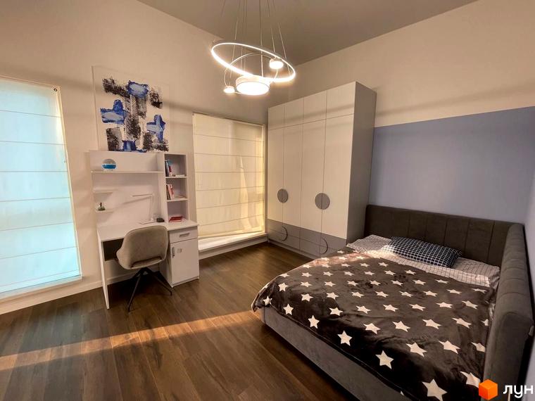 Спальня в будинку КМ Sunrise Residence з двоспальним ліжком, шафою та робочим столом. Затишна атмосфера для відпочинку та роботи.