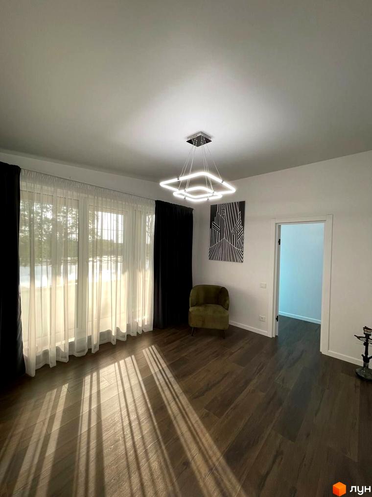 КМ Sunrise Residence: простора вітальня з великими вікнами та сучасним освітленням. Сонячні промені падають на дерев'яну підлогу.