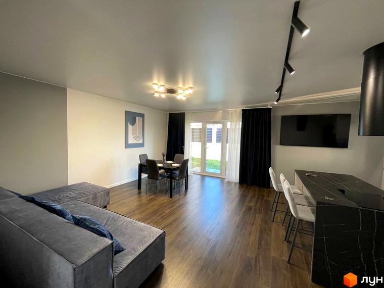 Інтер'єр вітальні з диваном, обідньою зоною та барною стійкою в комплексі КМ Sunrise Residence. Сучасний дизайн та функціональне планування.