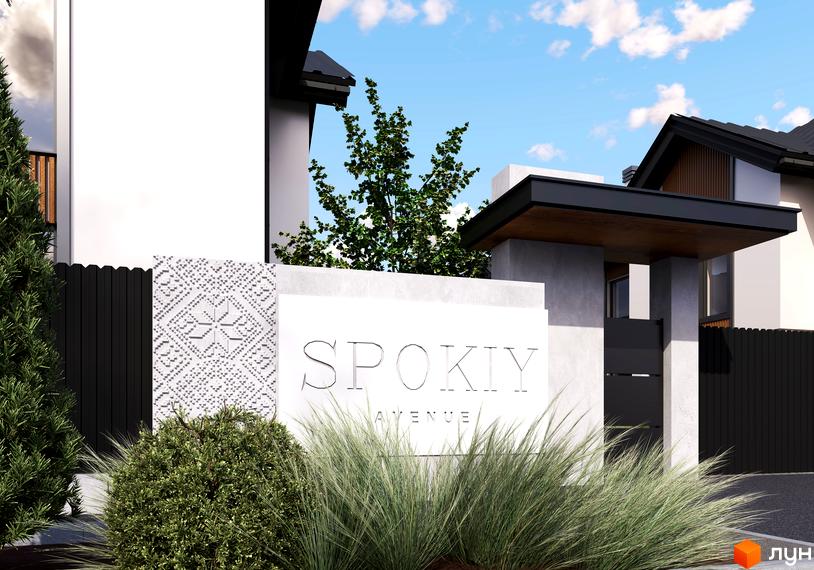 Котеджне містечко Spokiy Avenue з білою стіною та декоративним візерунком, оточене зеленню та парканом.