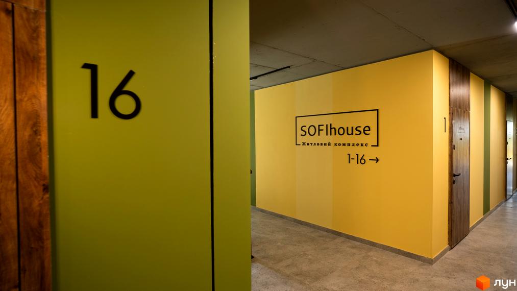 Житловий комплекс SOFI HOUSE: вхідна група з номером 16 та вказівником напрямку до квартир 1-16. Оздоблення стін у жовтих та зелених тонах.