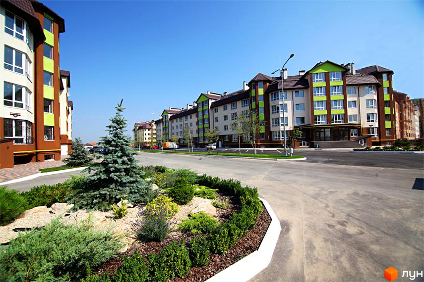 Зовнішній вигляд будівель житлового комплексу Львівський маєток. Навколо будівель облаштована прибудинкова територія з зеленими насадженнями та дорогою.