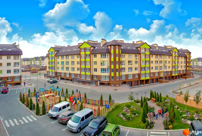 Житловий комплекс Львівський маєток. Багатоквартирні будинки з жовто-бежевими фасадами та зеленими елементами, поруч дитячий майданчик та зелена зона відпочинку.