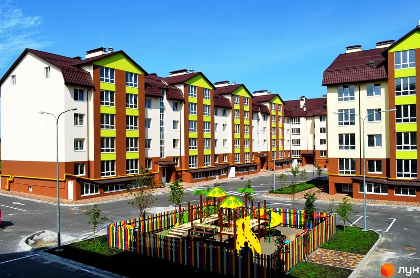 Житловий комплекс Львівський маєток з яскравим дитячим майданчиком. Сучасні будинки з коричневими та зеленими фасадами.