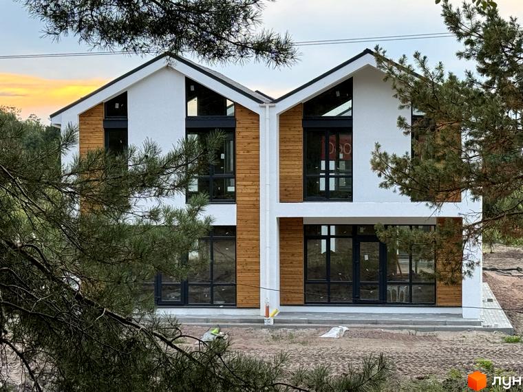 Дуплекси WoodSky з білими фасадами, дерев'яним оздобленням та панорамними вікнами. Прибудинкова територія з ґрунтовою ділянкою та соснами.