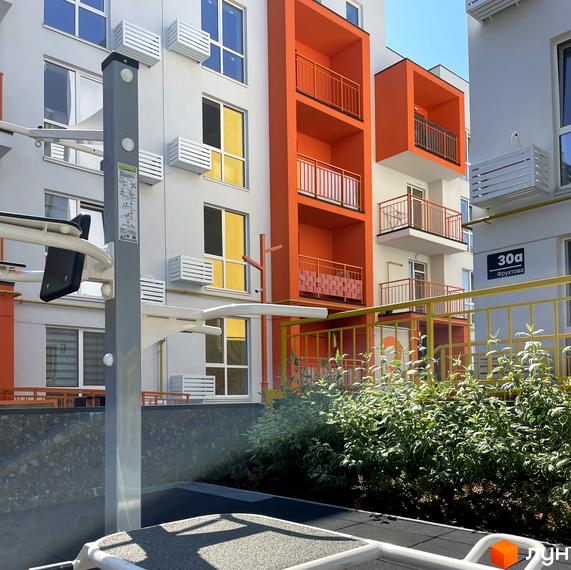 Житловий комплекс Art Misto з яскравим фасадом та балконами, поруч спортивний майданчик та зелена зона.