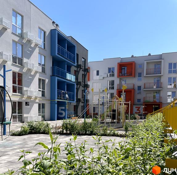 Житловий комплекс Art Misto з яскравими фасадами та дитячим майданчиком. Сучасна архітектура та доглянута прибудинкова територія.