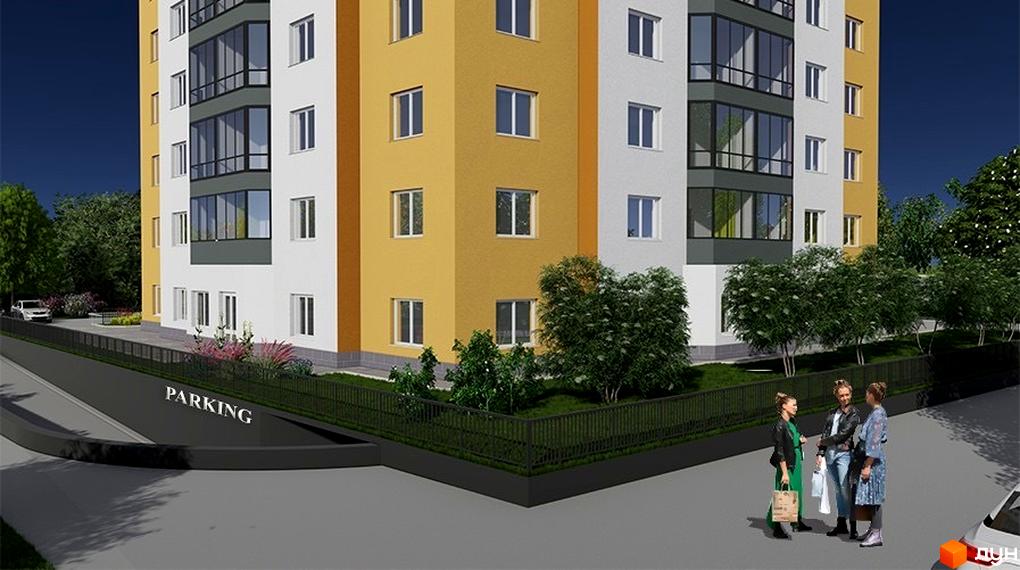 Житловий комплекс VOLDIM з жовто-білим фасадом та скляними балконами. На прибудинковій території зелені насадження та зона паркування.