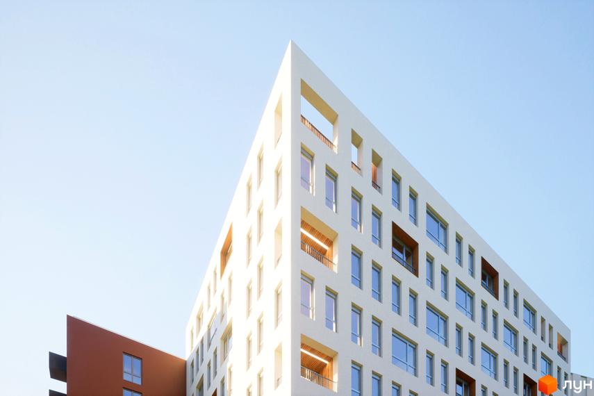 Зображення фасаду Будівельного проєкту САБ Борислав. На фотографії багатоповерховий будинок з великими вікнами на фоні блакитного неба.