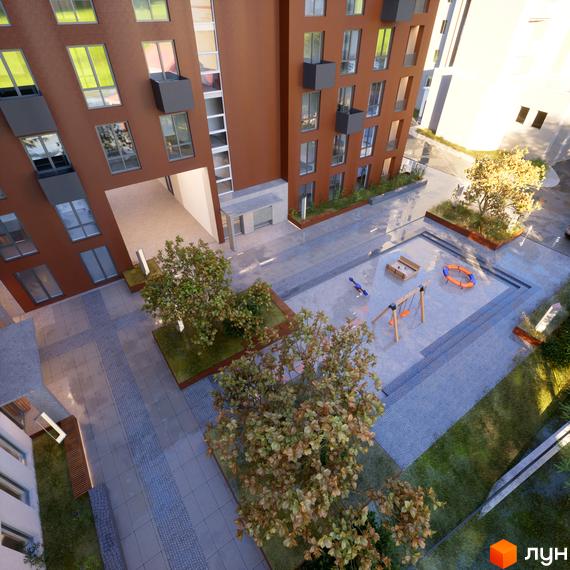 Вигляд зверху на будівлю та дитячий майданчик Житлового комплексу САБ Борислав. Навколо будинку ростуть дерева та кущі.