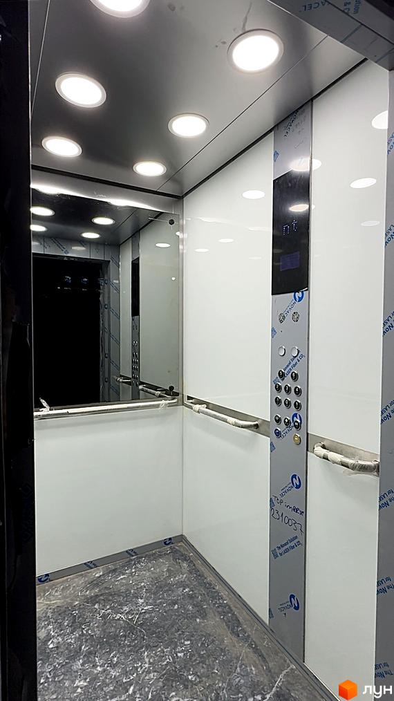 Інтер'єр ліфта в ЖК AcademHoff з дзеркалами, підсвіткою та панеллю керування. Сучасний дизайн та функціональність для комфортного пересування.