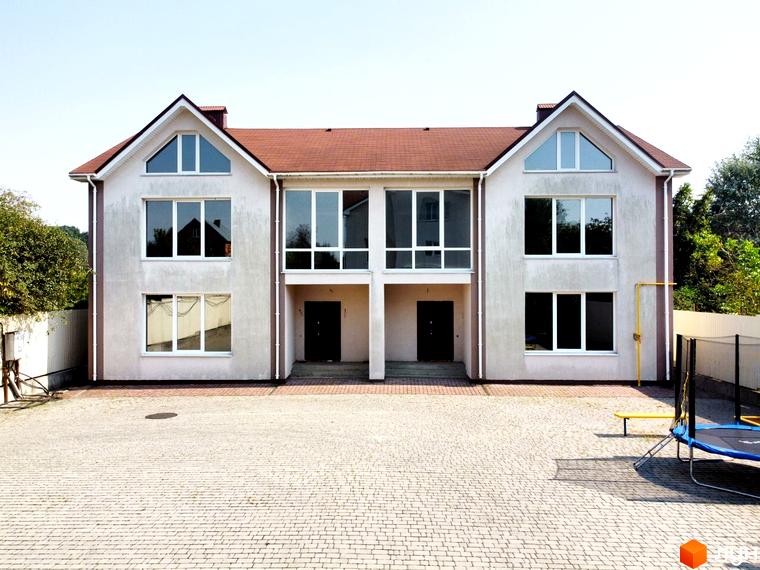 Котеджне містечко На Вишневій: двоповерхові будинки з великими вікнами та червоним дахом, вимощена бруківкою прибудинкова територія з батутом.