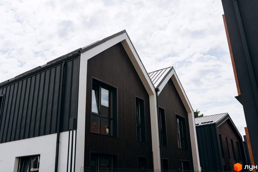 Котеджне містечко Garden Village Ozerne: фасади будинків з темними та білими елементами, металевий дах. Зовнішній вигляд новобудов.