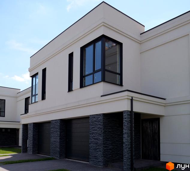 Зовнішній вигляд будинку Житловий комплекс по вул. Яблунева, 4-6 з гаражами та панорамними вікнами. Видно прибудинкову територію з бруківкою.