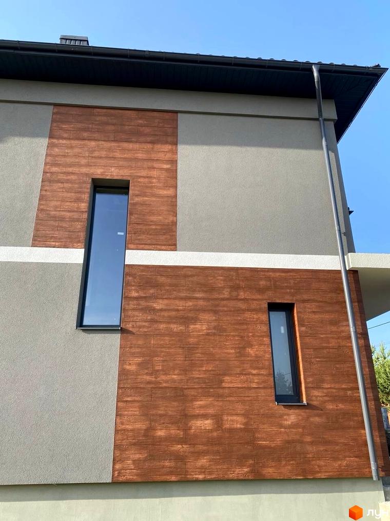 Фасад будинку з дерев'яними вставками та великими вікнами. Зовнішній вигляд новобудови на вулиці Волошкова.