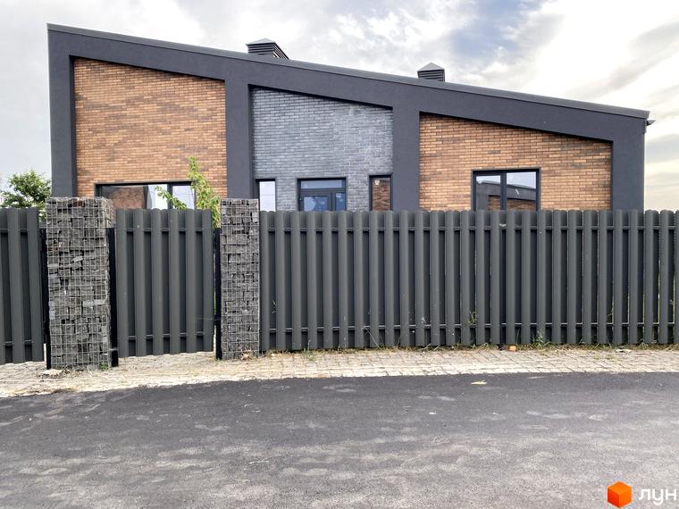 Котеджне містечко КМ Country Villa з фасадом з цегли та сірої плитки, огороджене металевим парканом із кам'яними стовпами.