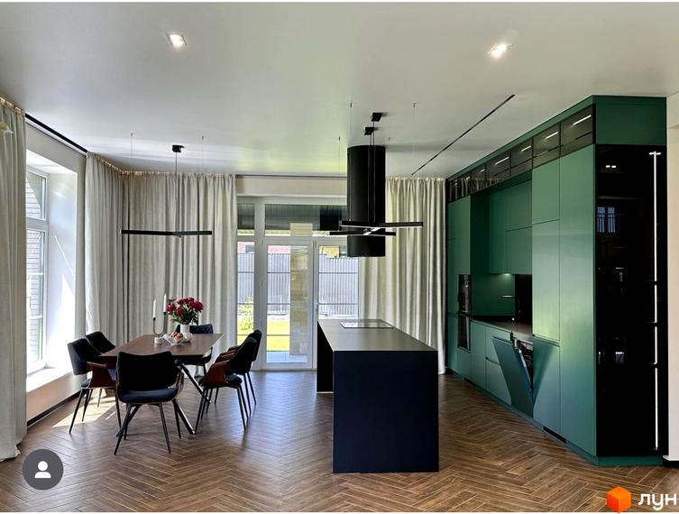 Простора кухня-вітальня в будинку КМ Spacious HOME з зеленими фасадами та обідньою зоною. Сучасний дизайн інтер'єру з острівною частиною та великими вікнами.