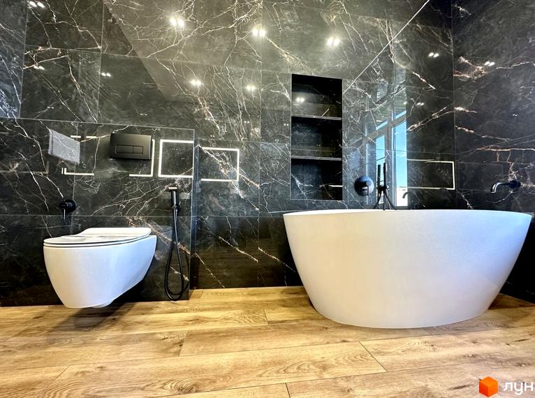 Простора ванна кімната з мармуровою плиткою та підвісним унітазом у житловому комплексі Spacious HOME. Сучасний дизайн інтер'єру з акцентом на елегантність та комфорт.