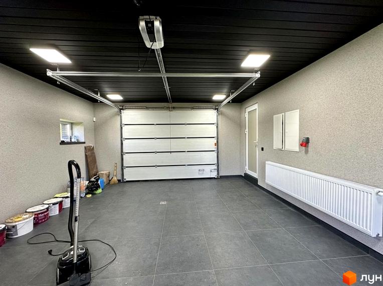 Гараж в житловому комплексі КМ Spacious HOME з підйомними воротами та опалювальним радіатором. Огляд внутрішнього простору новобудови.