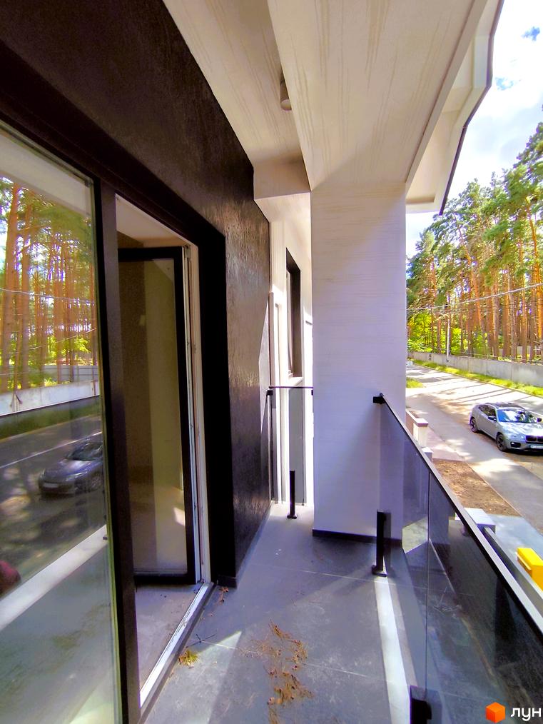 Зовнішній вигляд будинку Toscana Home з балконом та скляною огорожею, на тлі соснового лісу та дороги з автомобілем.